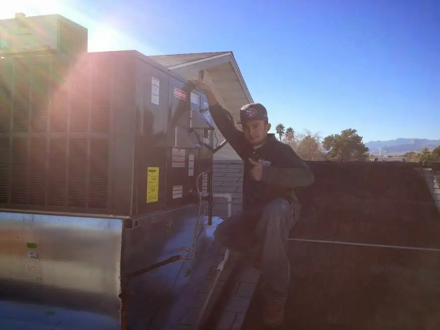 HVAC technician performing AC Tune-Up on a rooftop unit in Lodi
