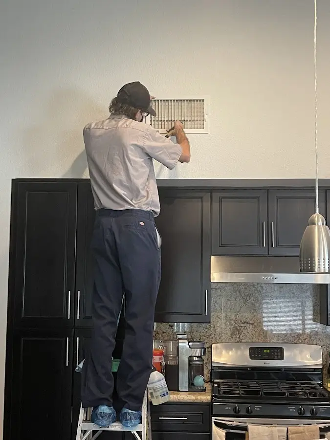 Technician inspecting an air vent during HVAC service in Lodi